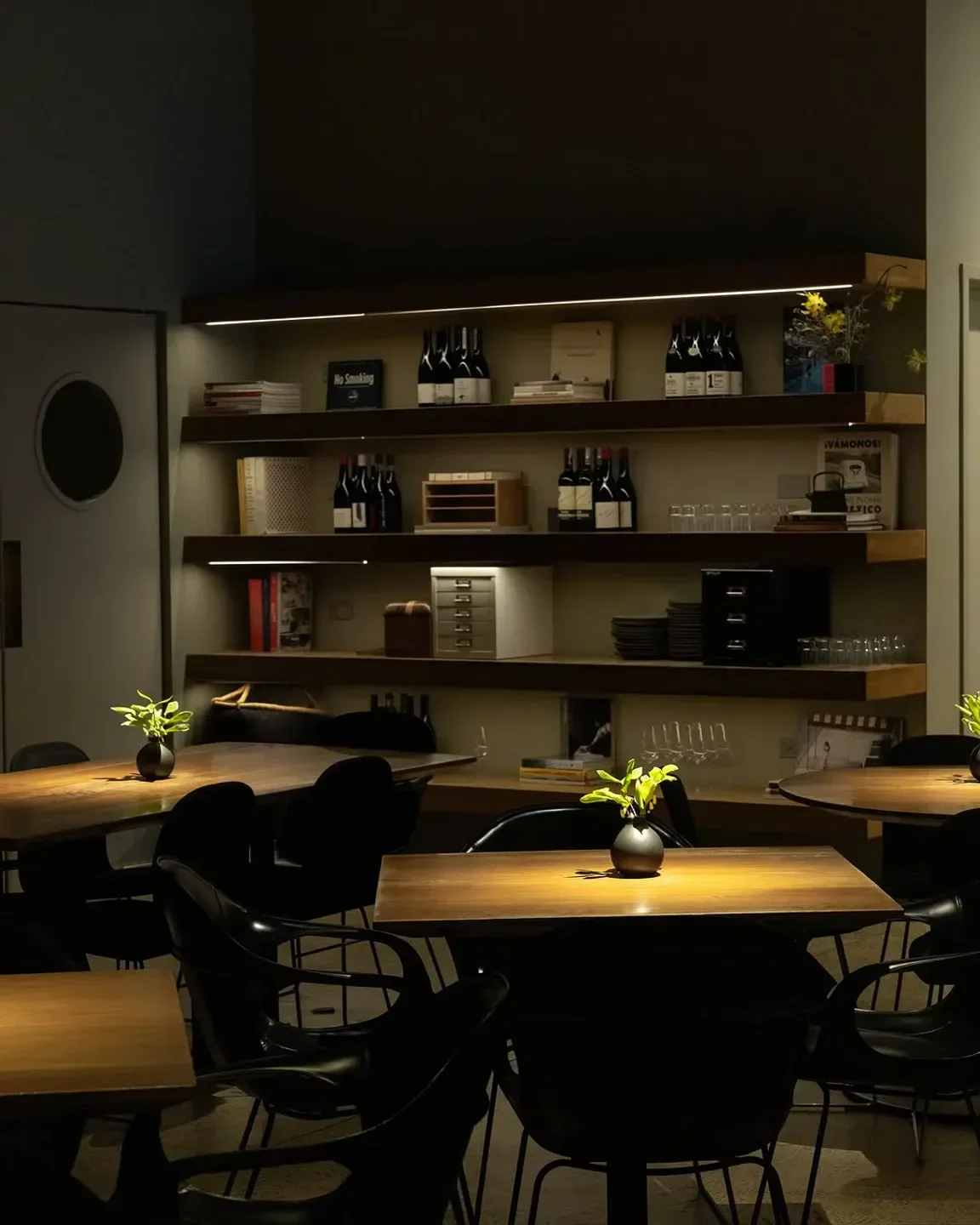 Interior of Cosme restaurant in New York City with wooden tables and shelves