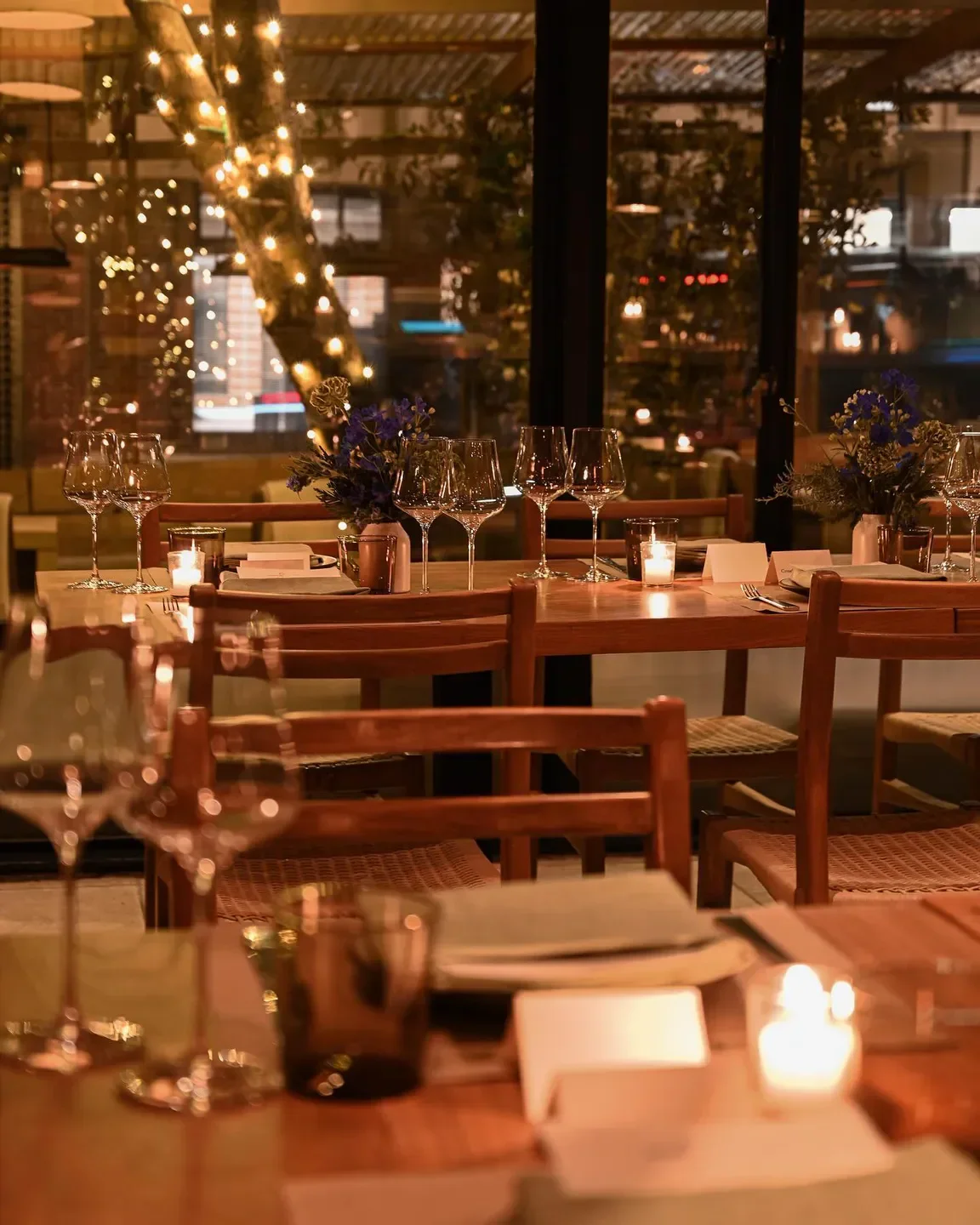 Cozy dining area at Cotogna restaurant in San Francisco with candles and wine glasses.