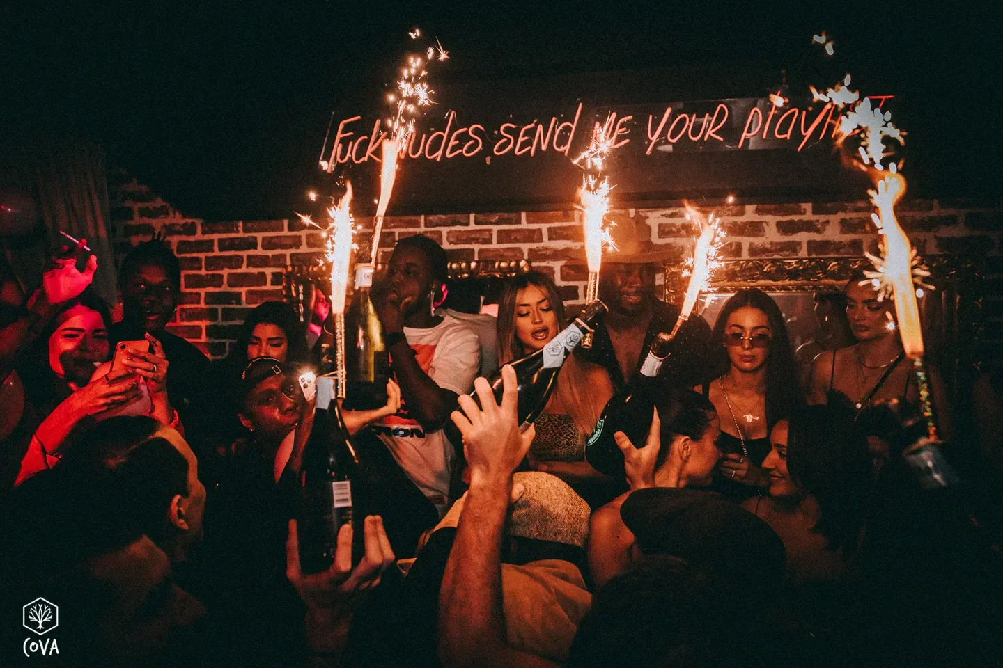Party scene at Cova nightclub in Paris with champagne and sparklers.