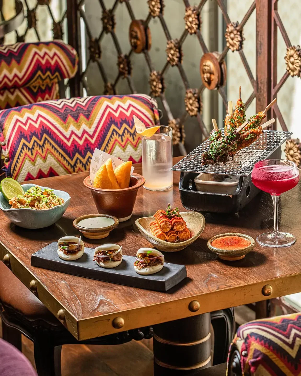 Delicious spread of food and drinks at COYA Paris restaurant, including skewers and sliders.