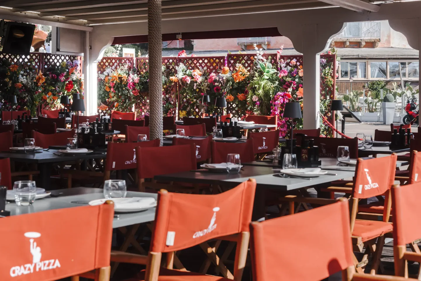 Crazy Pizza Porto Cervo restaurant interior with vibrant floral decor and red seating