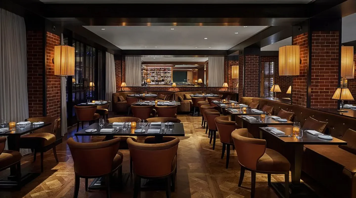 Interior of CUT by Wolfgang Puck - DC, a restaurant in Washington, with a warm ambiance.