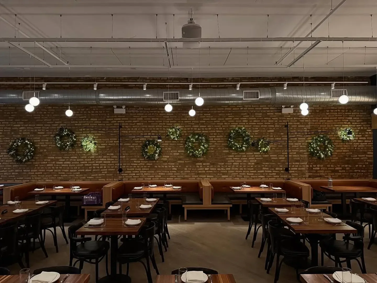 Interior of Daisies restaurant in Chicago featuring brick wall and elegant dining setup.