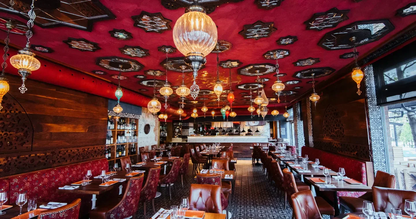 Interior of Damas restaurant in Montreal with ornate ceiling and hanging lights.