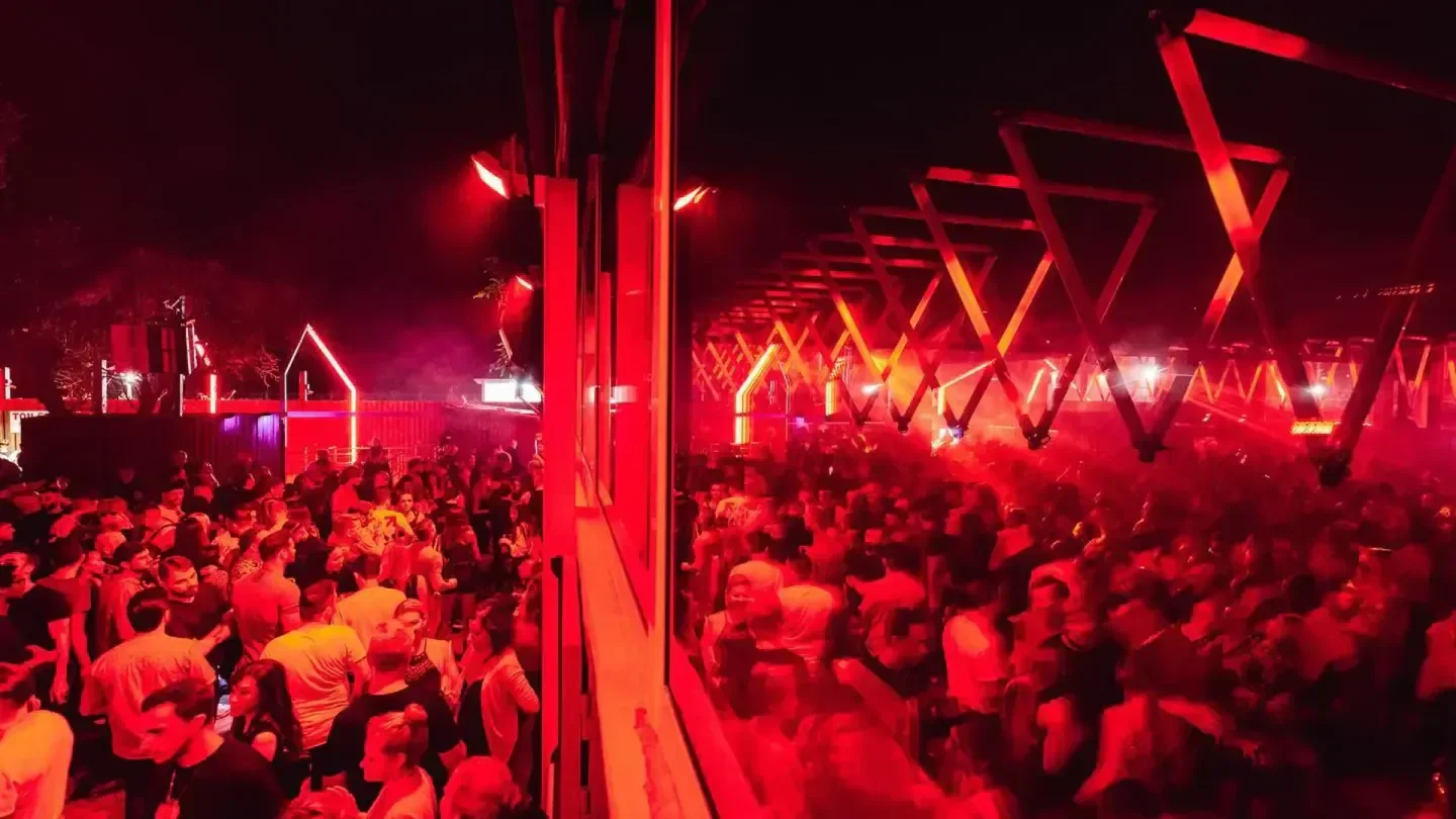 DC10 Ibiza nightclub with vibrant red lighting and a large crowd enjoying the party.
