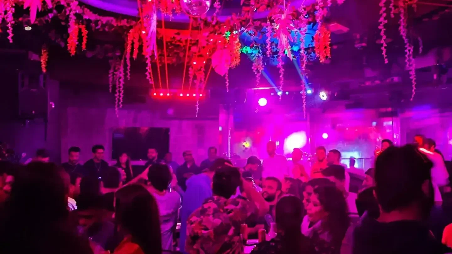 Inside De Club in Doha: Lively nightclub scene with people and vibrant lighting.