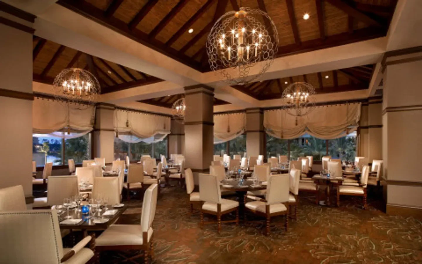 Dining room at Deep Blu Seafood Grille in Orlando with elegant chandeliers and seating.