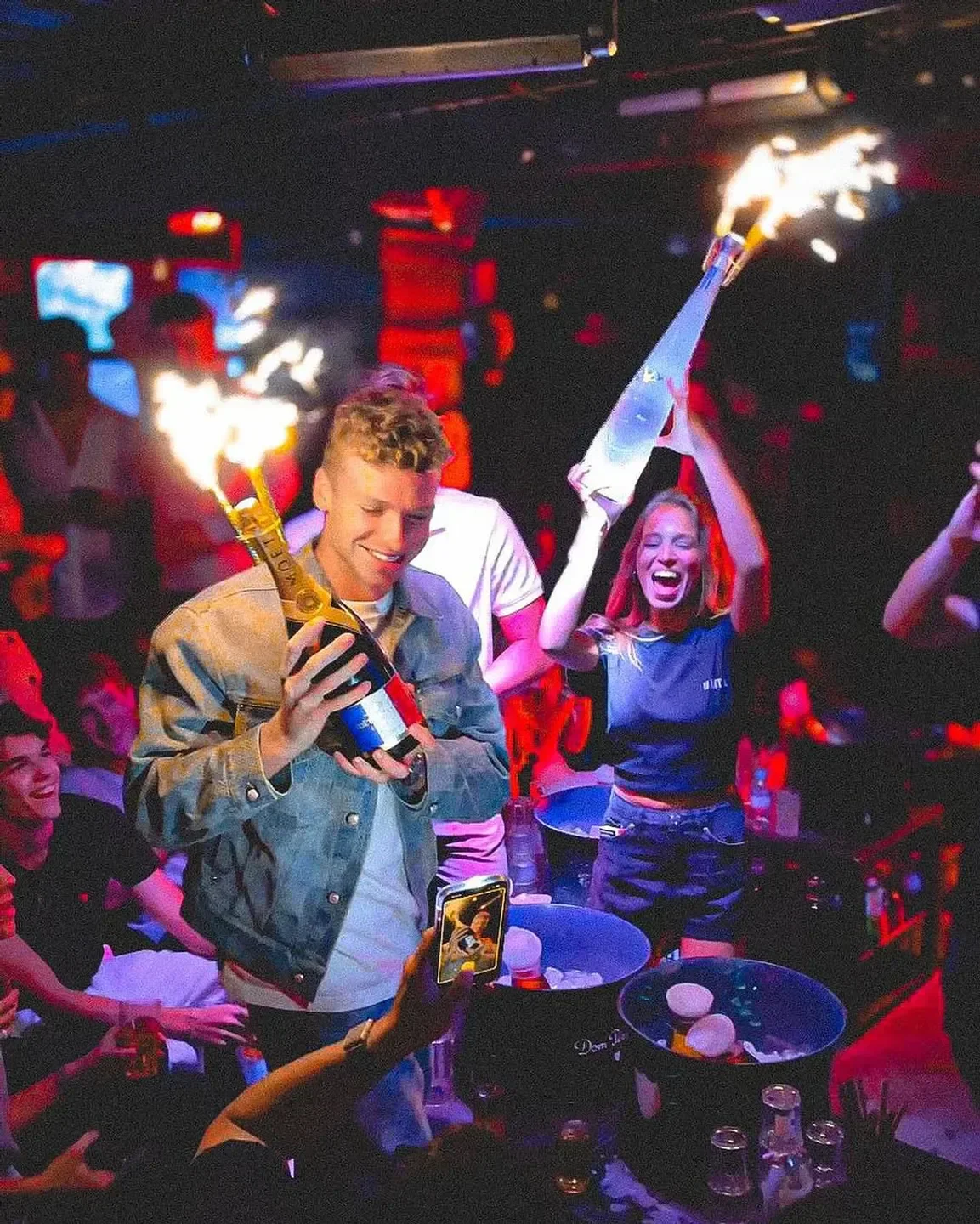 Celebration with sparklers at Deflower nightclub in Paris. Partygoers enjoying drinks.