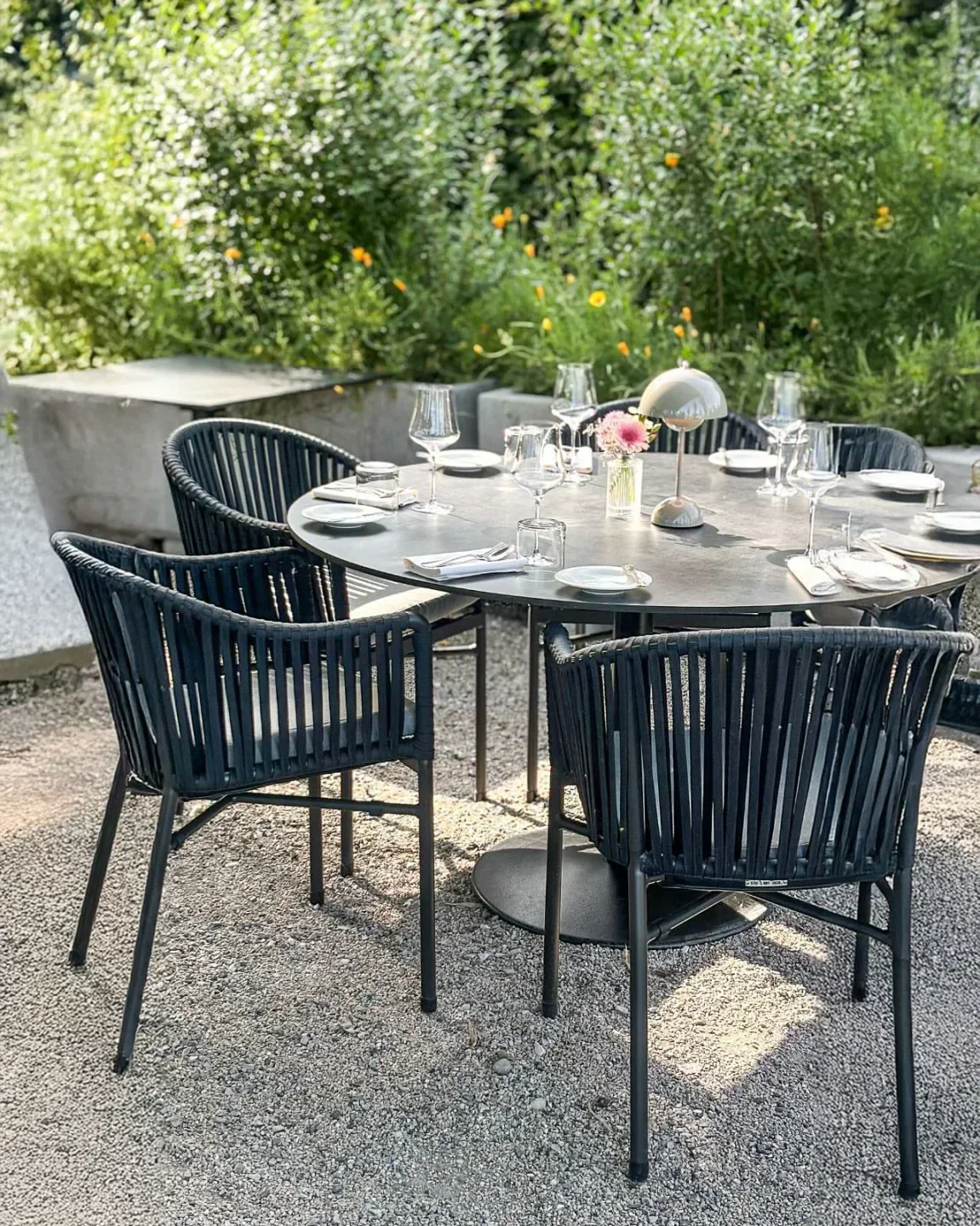 Outdoor dining at die Wöschi restaurant in Zurich, set table with chairs and flowers