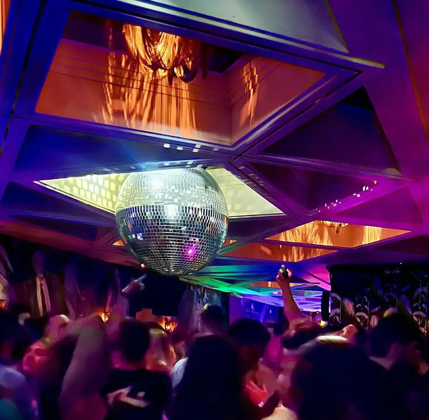 Disco Chicago nightclub with a disco ball and people dancing under colorful lights.