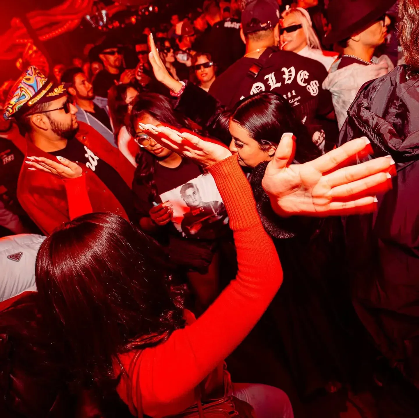 Dancing crowd at Discopussy nightclub in Las Vegas with red lighting and vibrant energy.