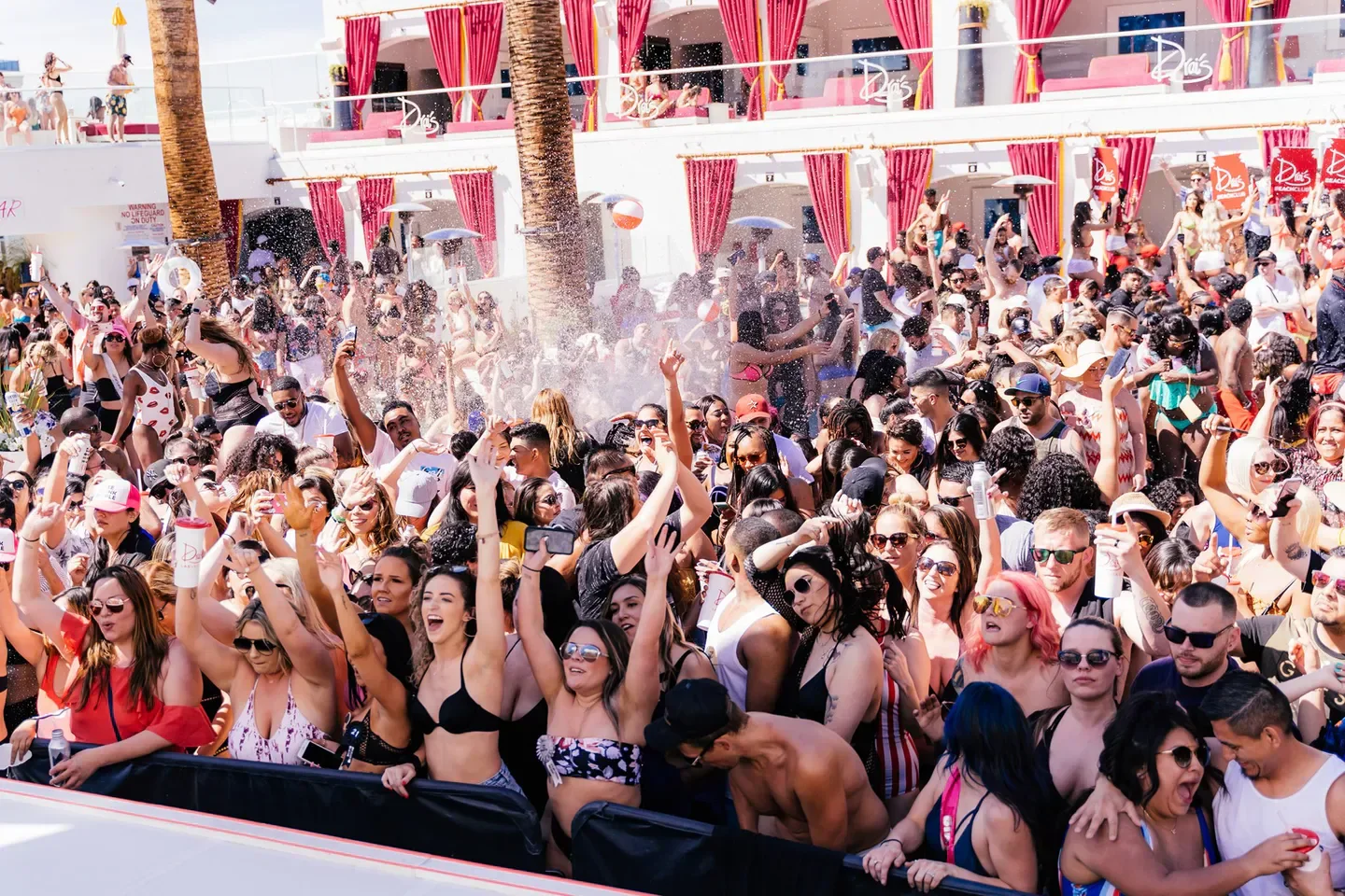 Crowded pool party at Drai's Beach Club in Las Vegas, with people dancing and spraying water