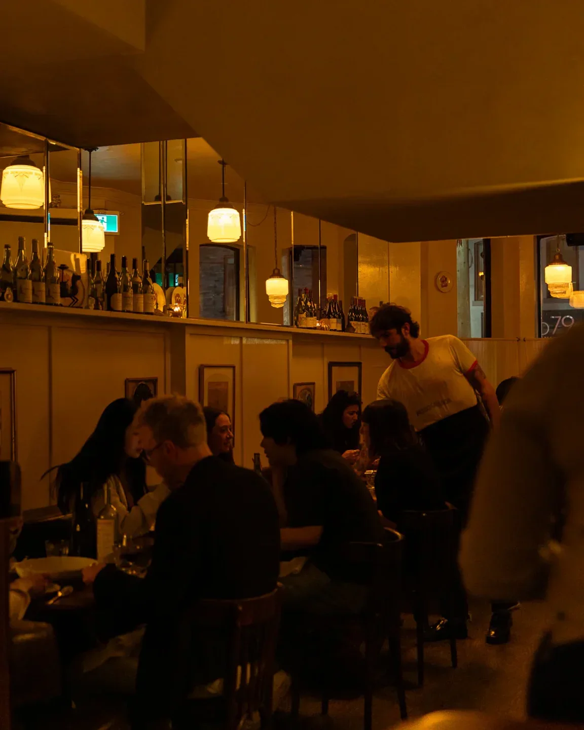 Cozy interior of Dreyfus restaurant in Toronto, with diners and staff present.