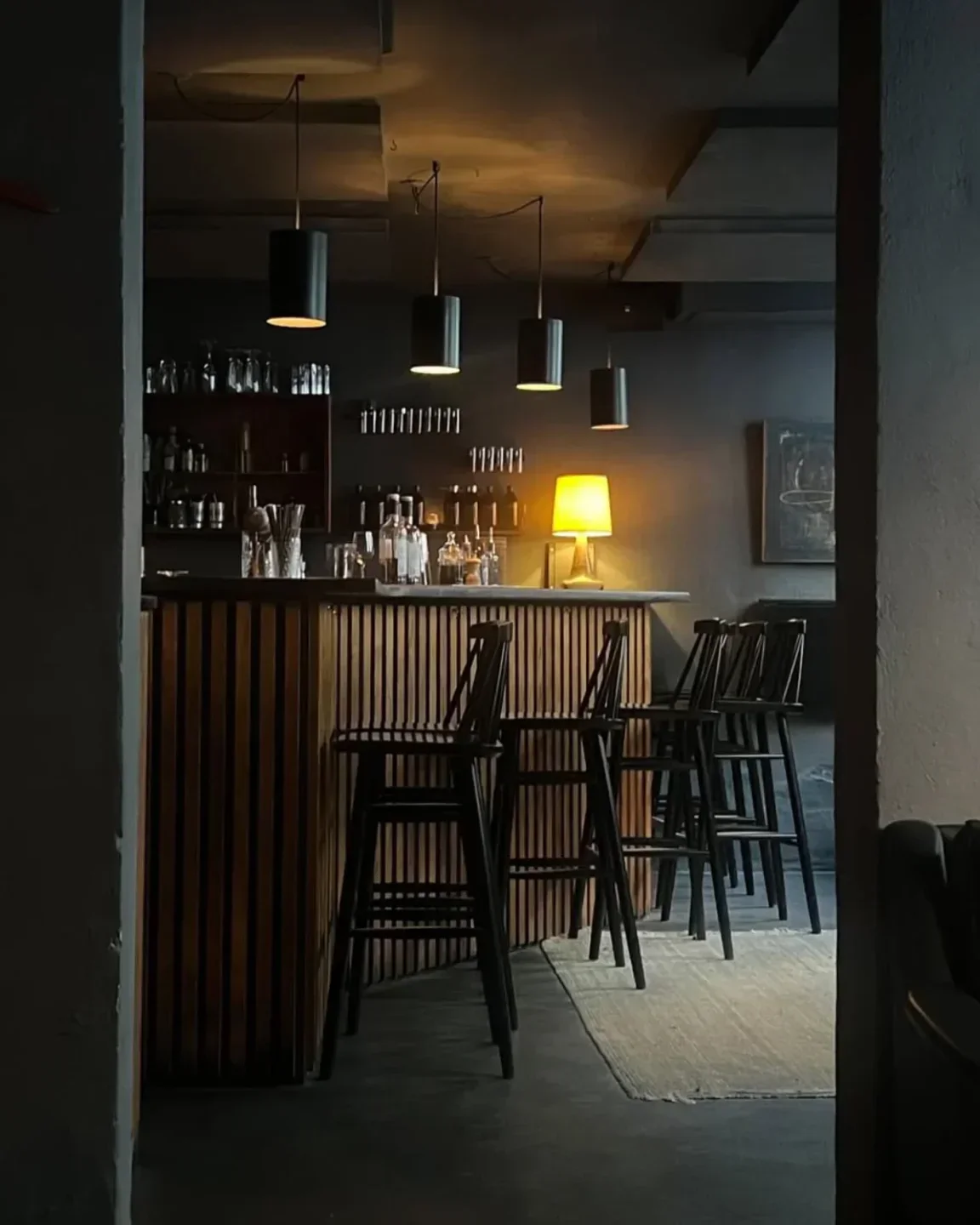 Cozy bar interior at Duck and Cover in Copenhagen, featuring stylish stools and warm lighting.