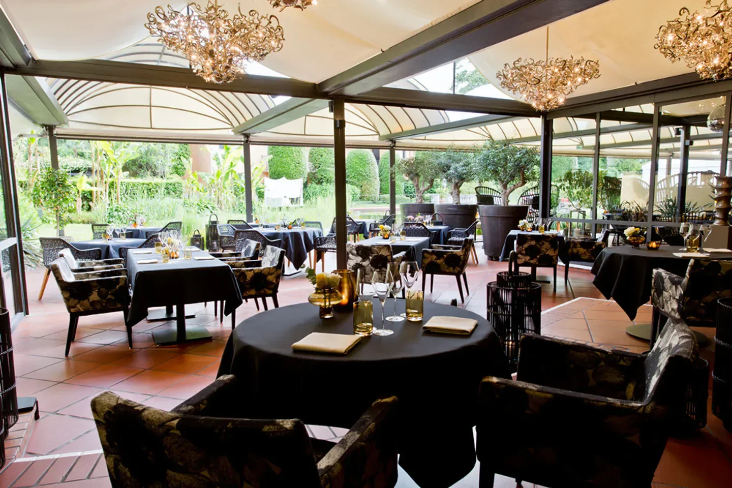 Ecco restaurant in St. Moritz: elegant interior with floral chairs and chandeliers.