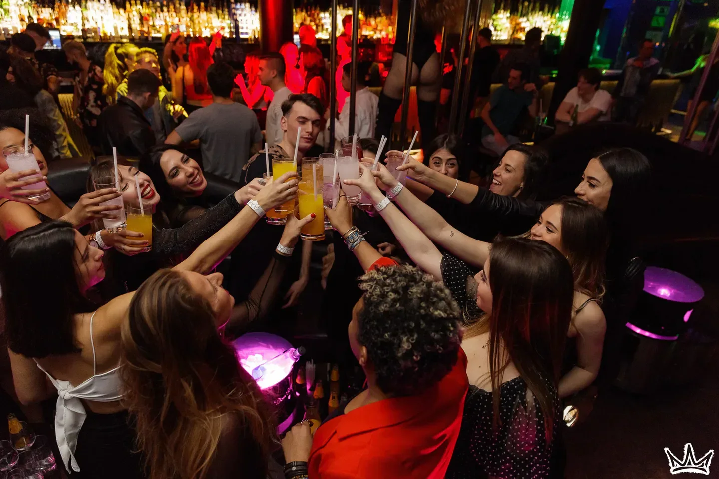 Cheers at Eclipse nightclub in Barcelona. Women toasting cocktails at the bar.