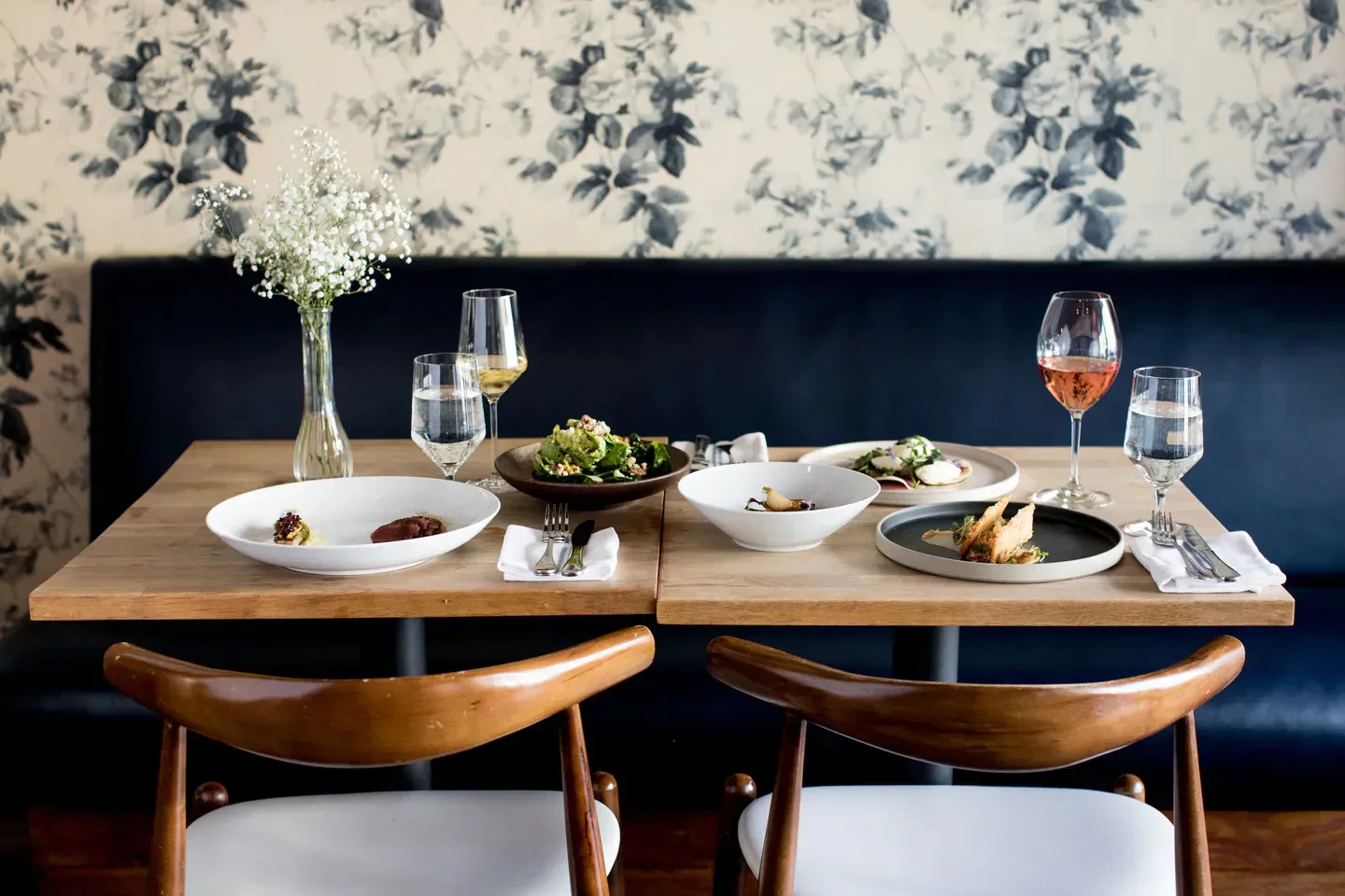 Table setting at Eden Hill restaurant in Seattle with plates of food and wine glasses.