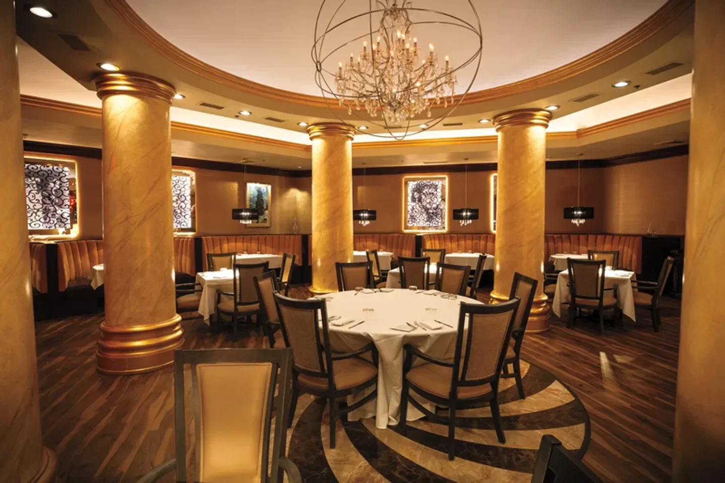 Elegant interior of Edge Steakhouse in Las Vegas with round tables and chandelier.