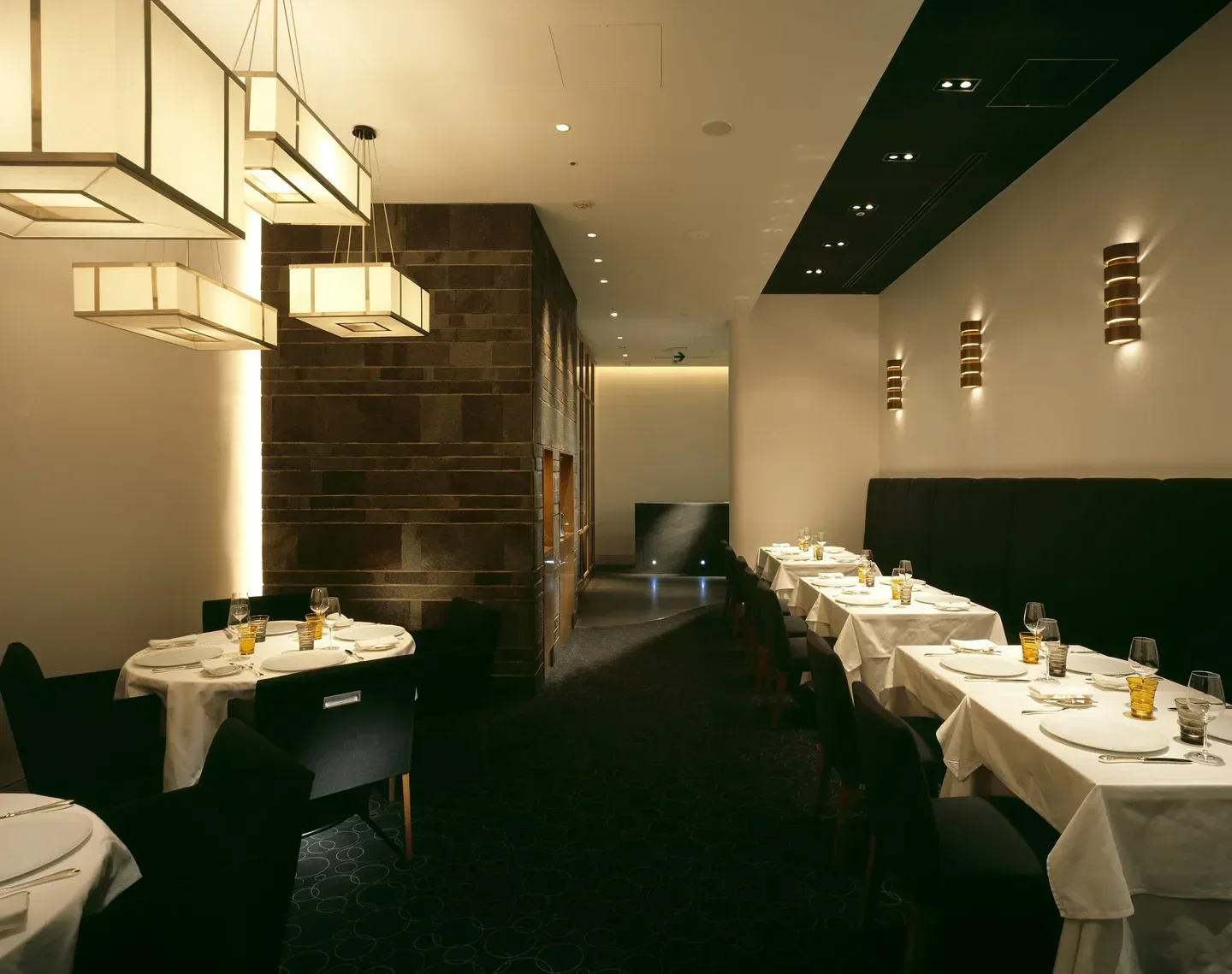 Elegant interior of Édition Koji Shimomura restaurant in Tokyo, featuring stylish lighting and tables.