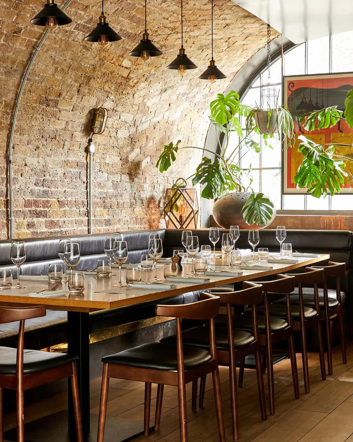 Elegant dining at El Club Allard in Madrid, with brick walls and stylish lighting.