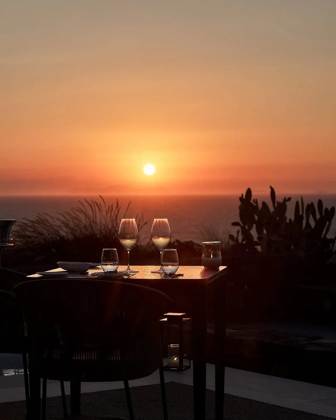 Set table at Elements restaurant with ocean view during a vibrant sunset.