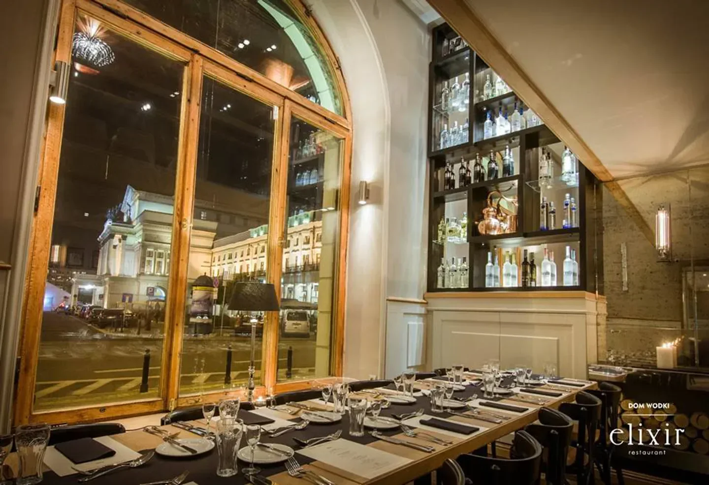 Elegant dining at ELIXIR restaurant in Warsaw, with a view of the city at night.