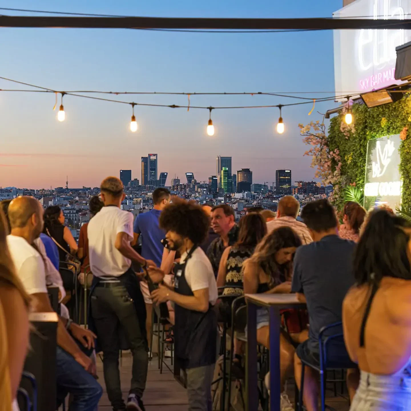 Ella Sky Bar in Madrid rooftop at dusk with city views and people dining.