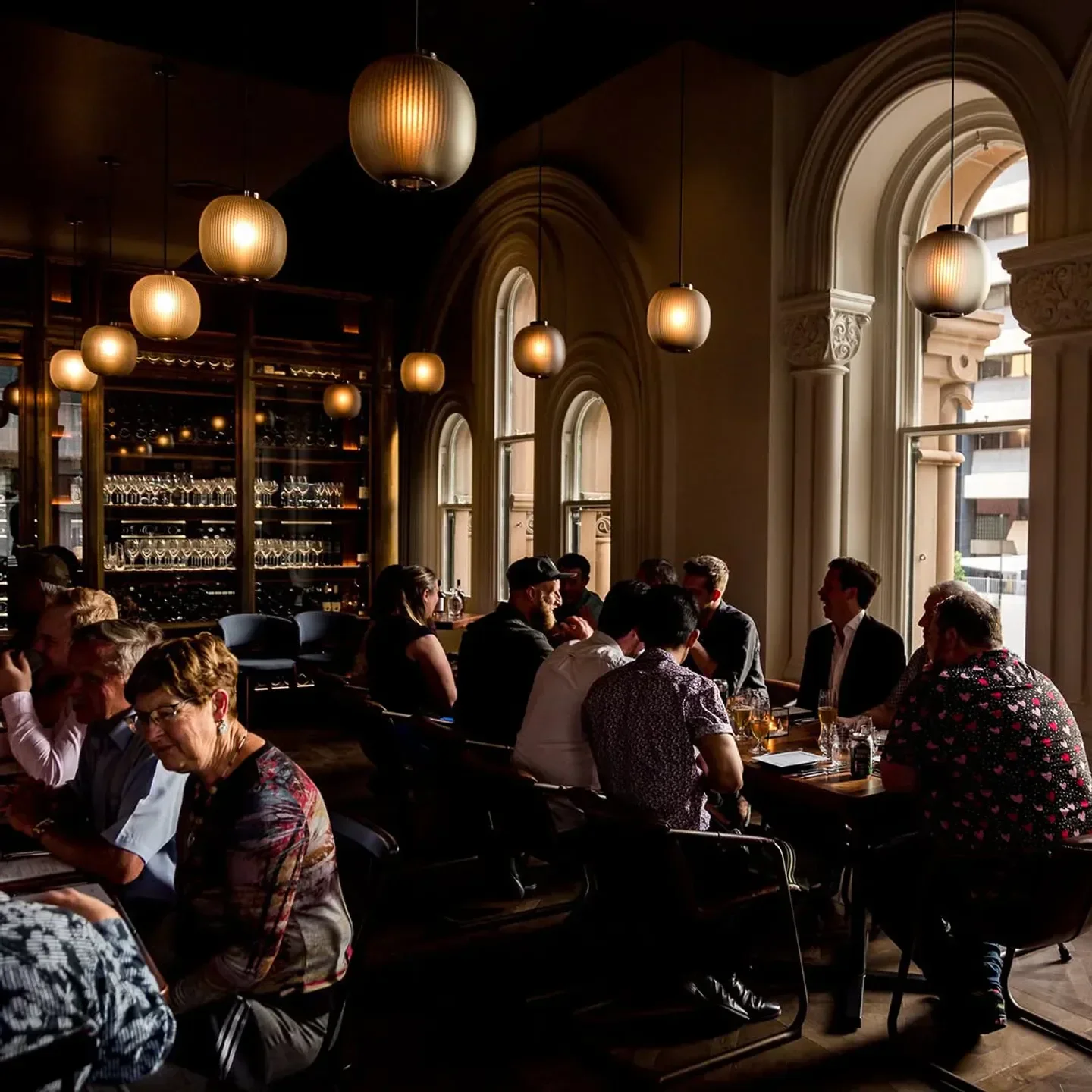 Elegant dining at ESQ Bar Dining in Sydney, featuring ambient lighting and arched windows.