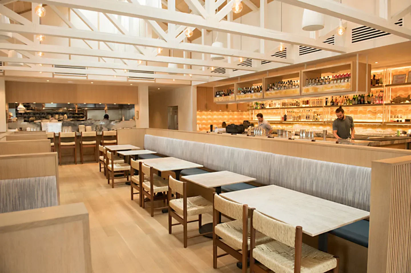 Interior of Este restaurant in Austin, featuring bar, seating and kitchen view