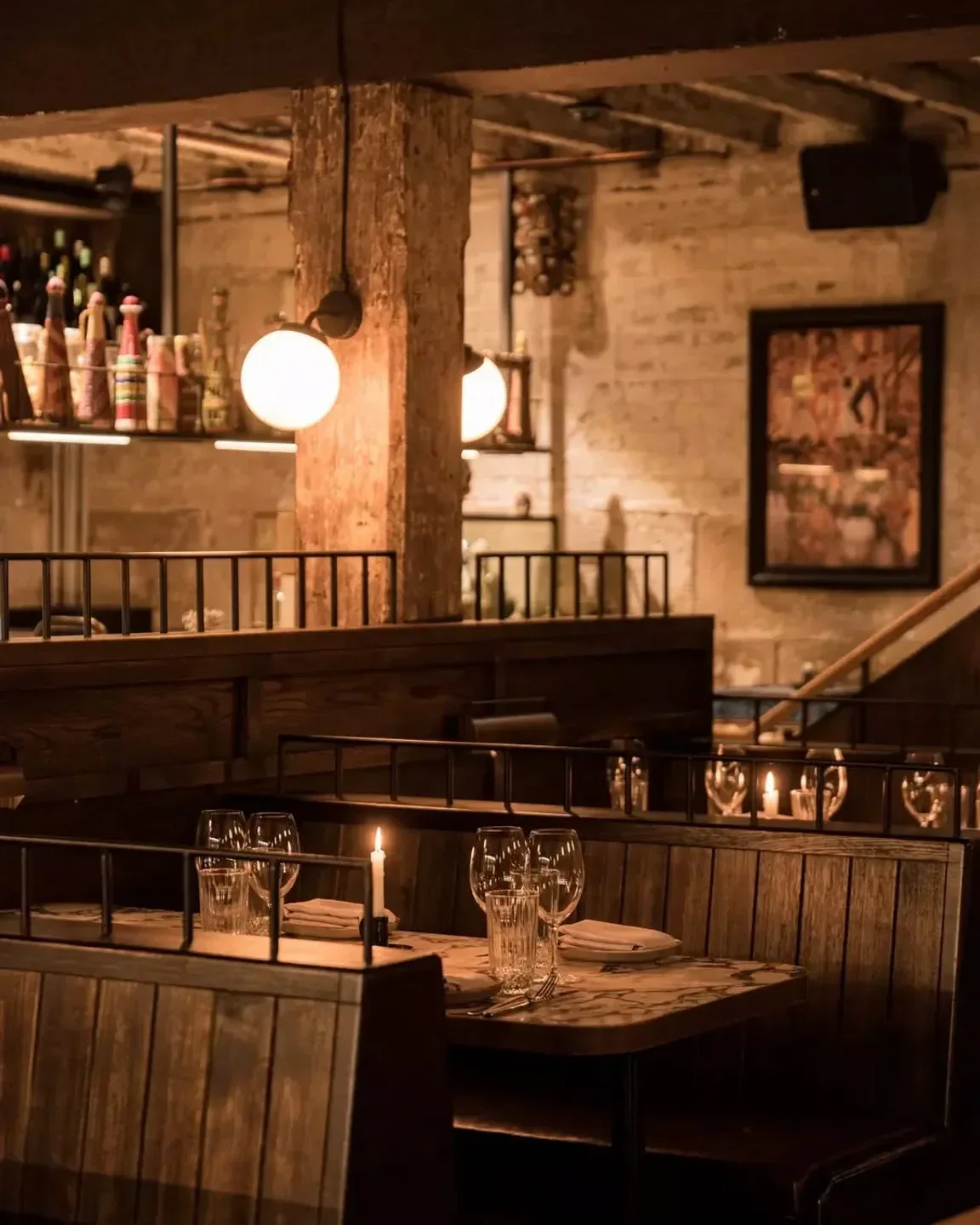 Cozy dining area at Esteban restaurant in Sydney, featuring lit candles and wooden booths.
