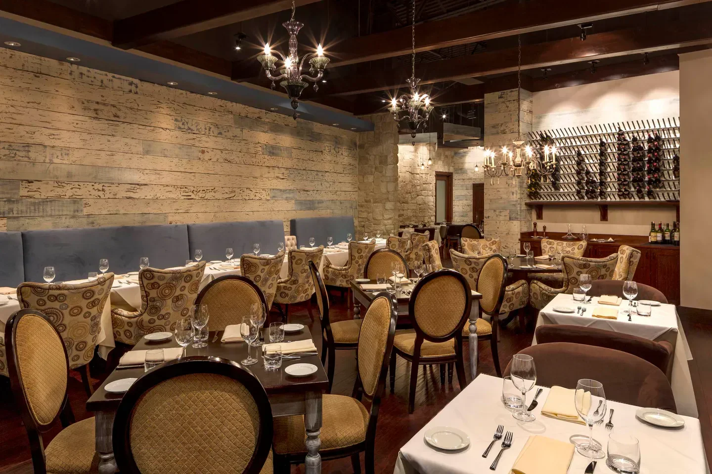 Cozy dining room at Etoile in Houston with elegant decor and wine display.