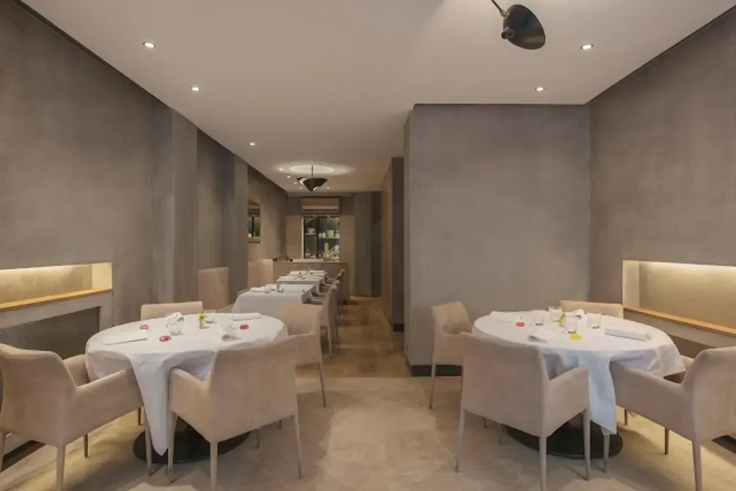 Elegant dining room interior at Étude in Paris, featuring round tables and soft lighting.