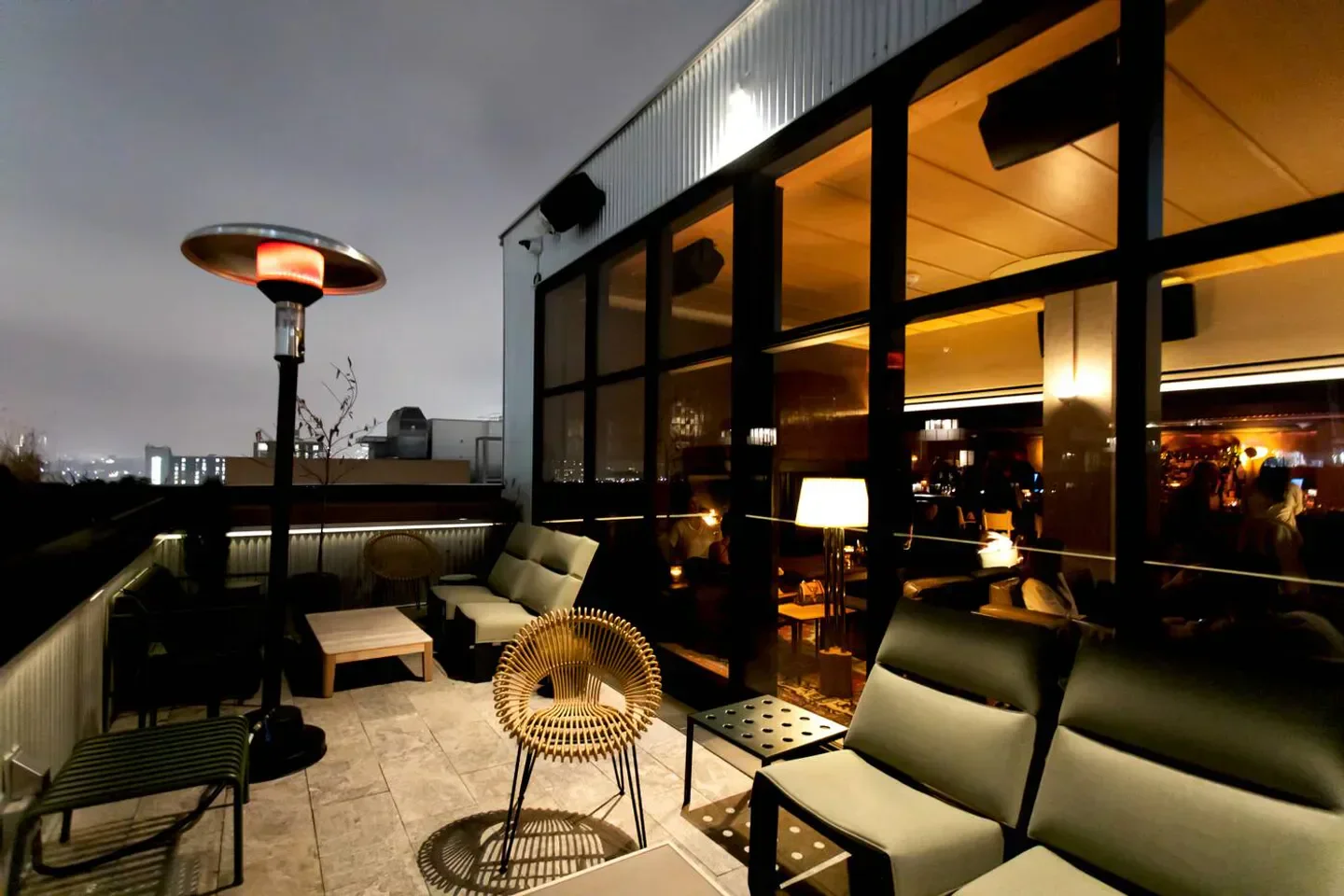 Rooftop patio at Evangeline restaurant in Toronto, with heaters and city views at night.
