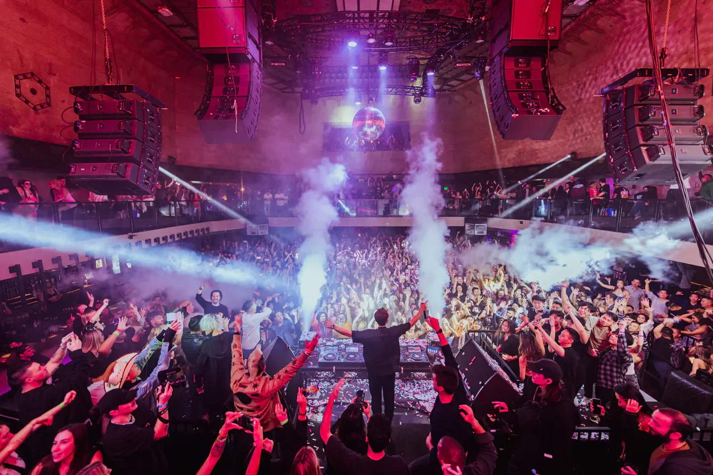 Energetic crowd at Exchange nightclub in Los Angeles with DJ and light show