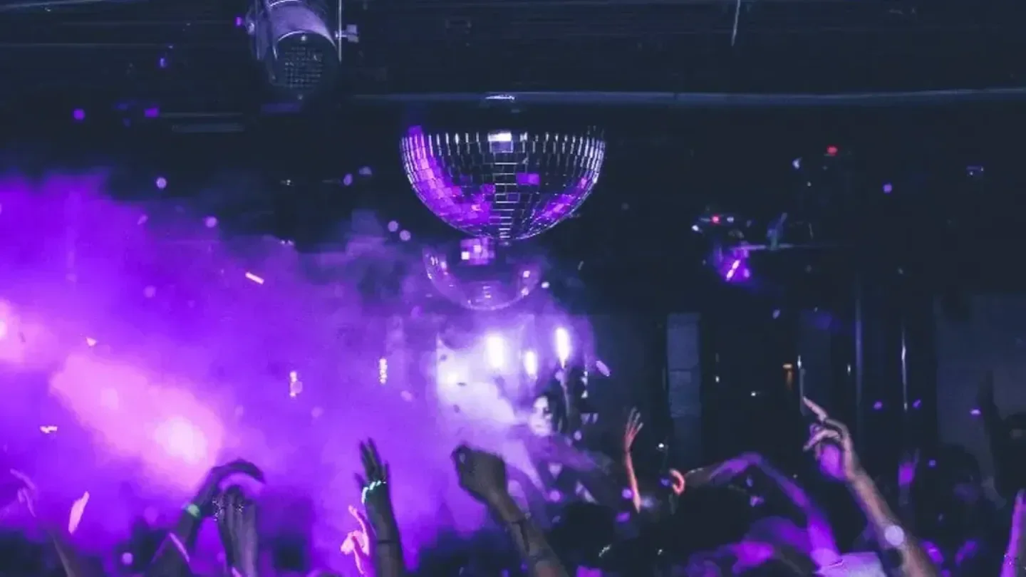 Disco ball and crowd at F6ix nightclub in San Diego with purple lights.
