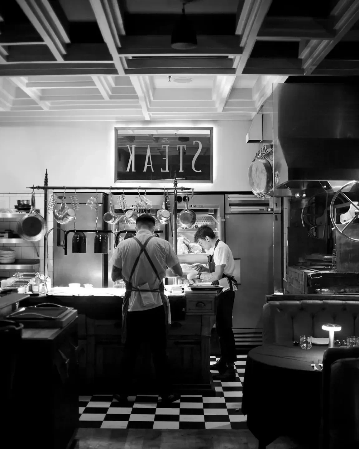 Chefs preparing food at Fia Steak in Los Angeles, captured in black and white.