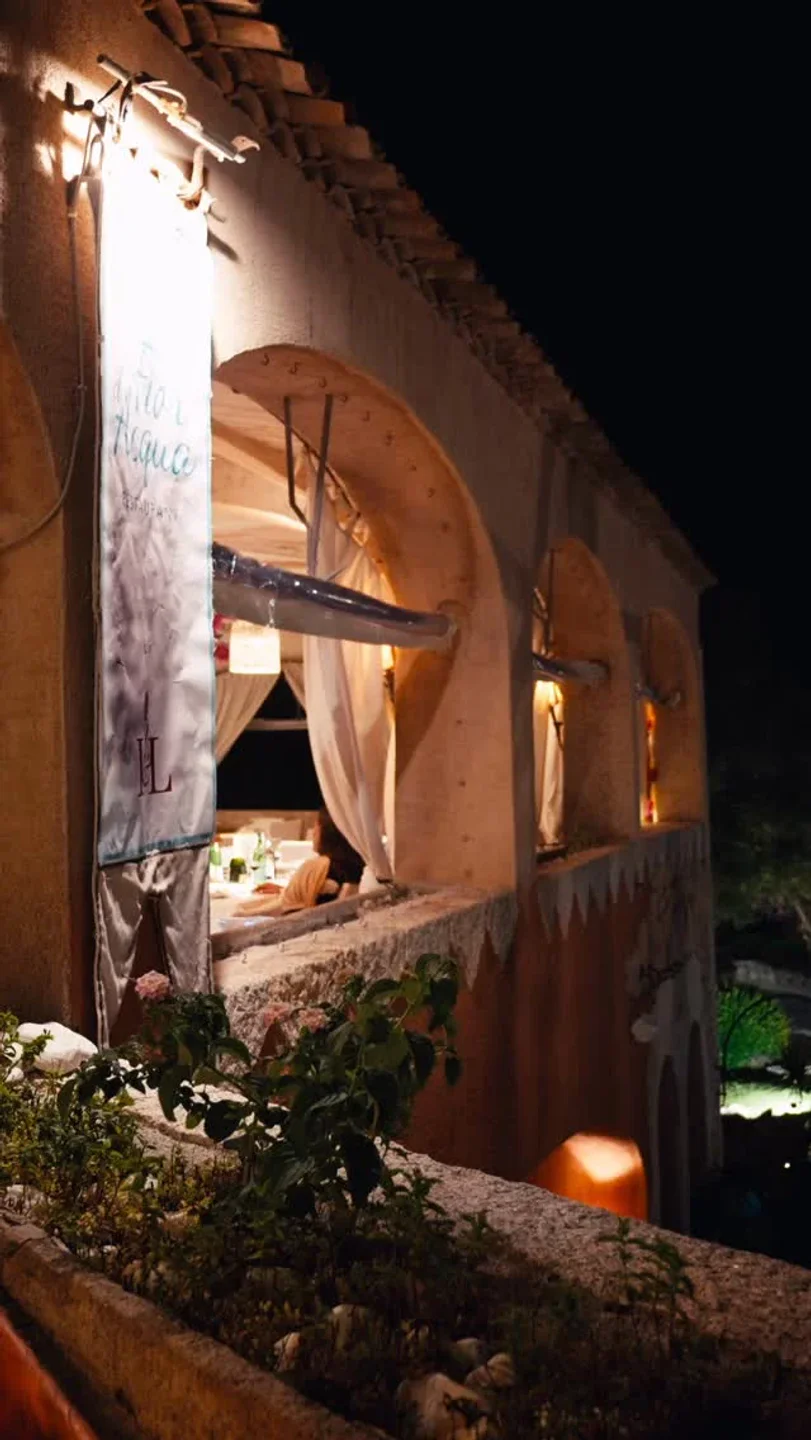 Fior d'Acqua restaurant in Porto Cervo at night, with arched windows and elegant table setting visible