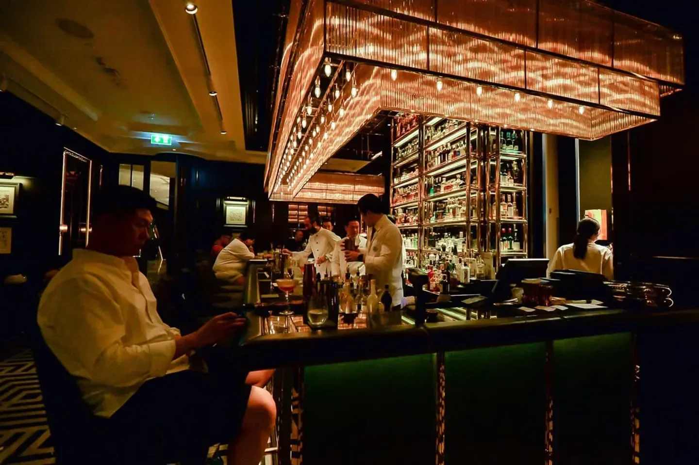Interior of Firefly Bar in Bangkok. Stylish bar with bartenders and well-stocked shelves.