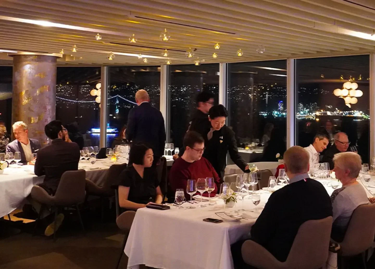 Elegant dining at Five Sails Restaurant in Vancouver, with city views at night.