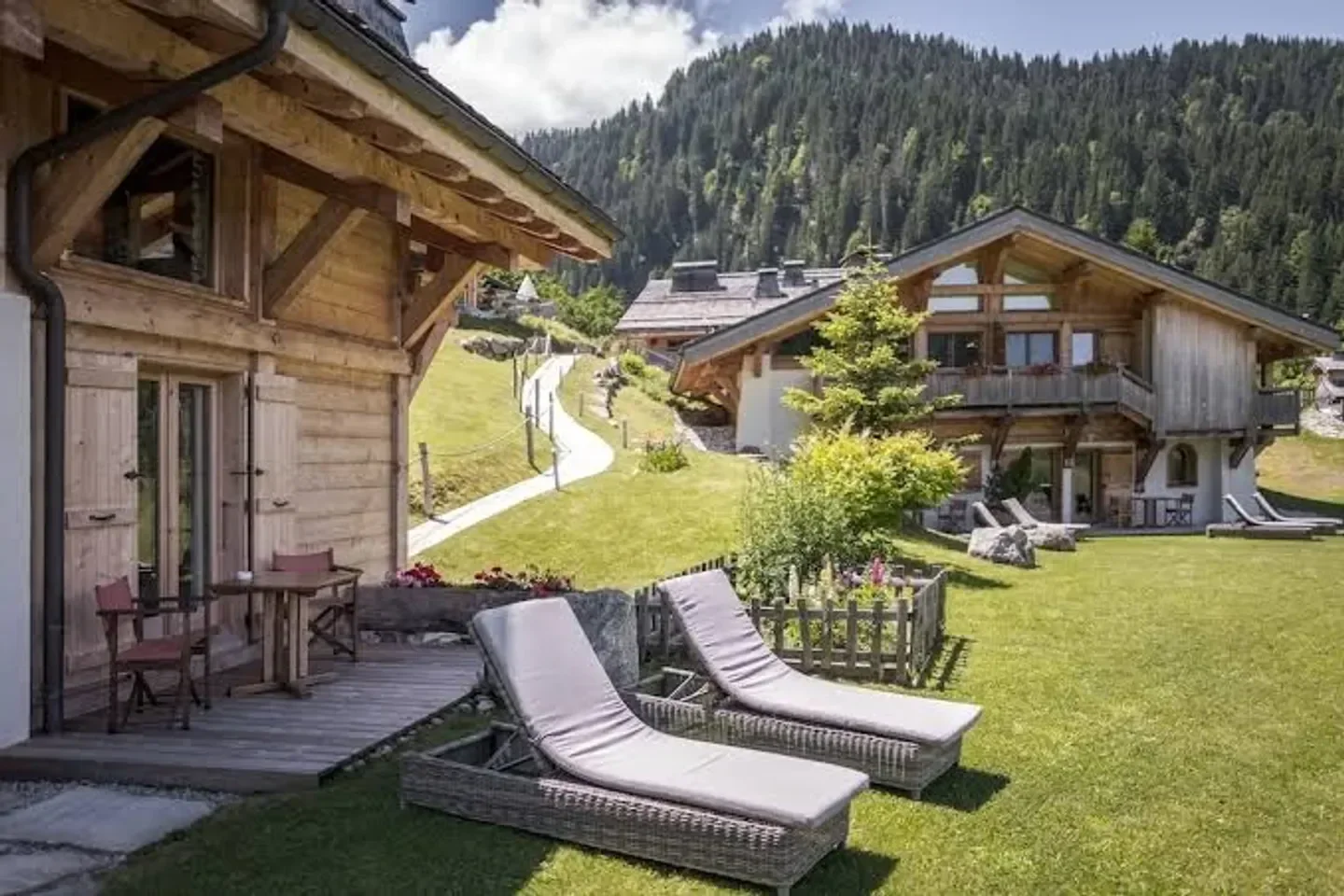 Exterior of Flocons de Sel restaurant in Megeve, with lounge chairs and mountain views.