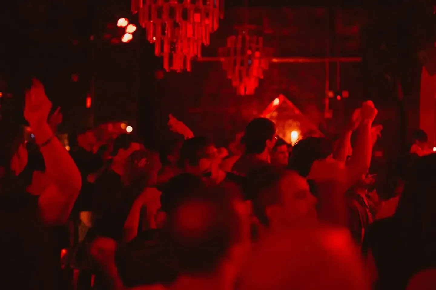 Energetic crowd at Floyd Miami nightclub dancing under red lights.