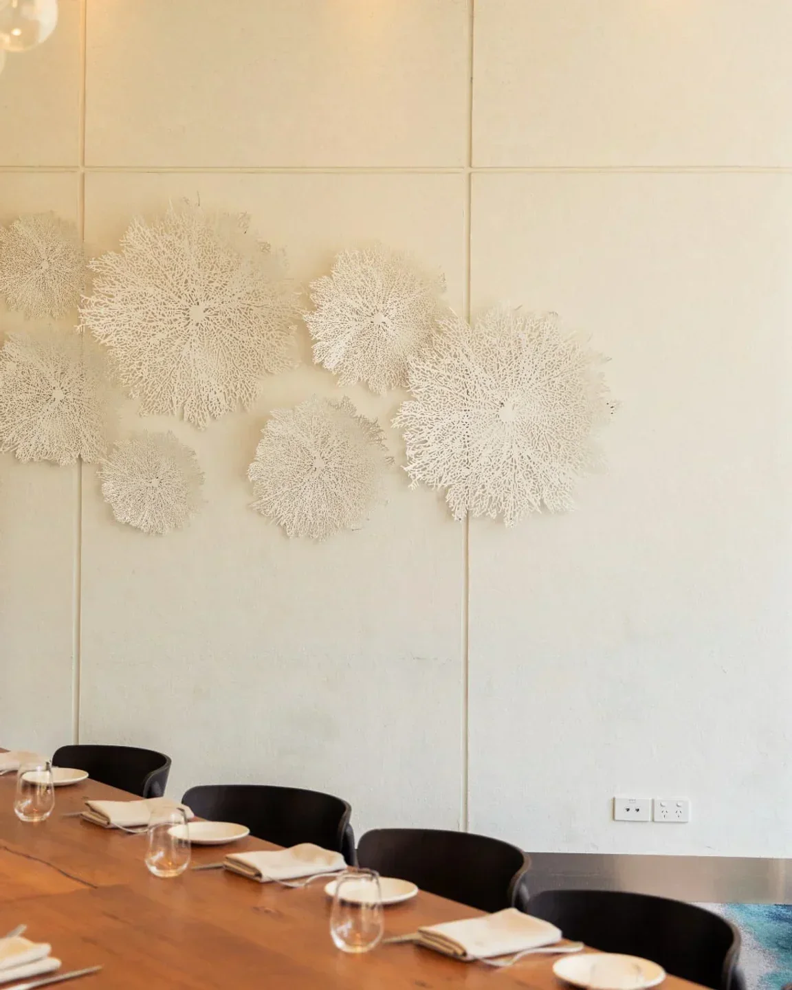 Interior of Flying Fish restaurant in Sydney, with decorative wall art and dining setup.