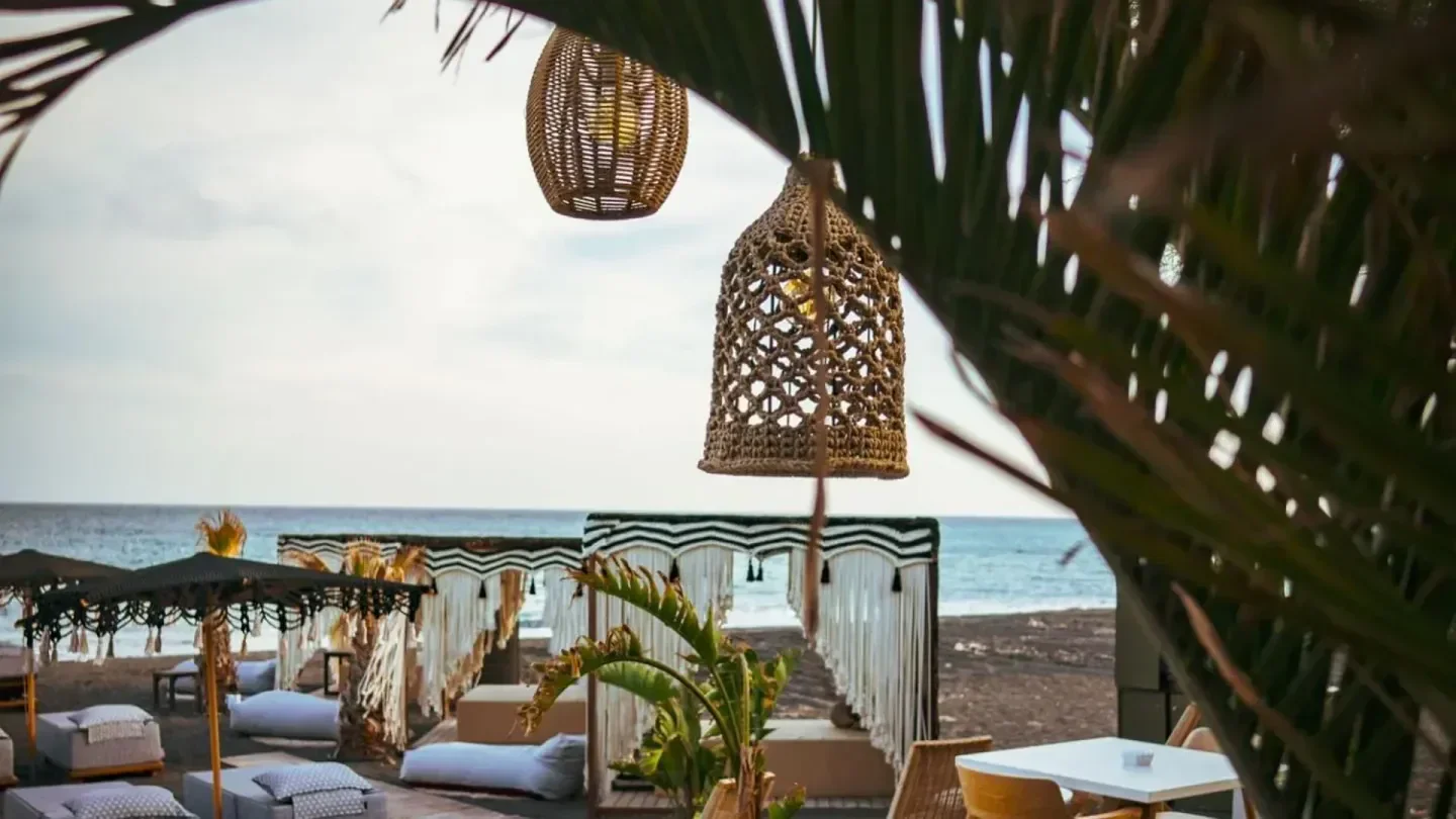 Relaxing beach scene at Forty One beach club in Santorini, with decorative lamps.