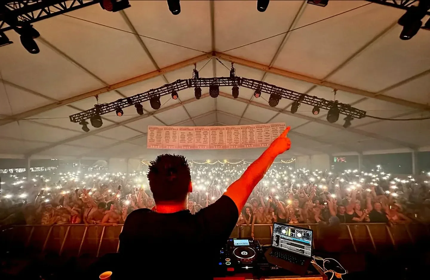 DJ at Foundation Room Las Vegas performs to a large crowd with lights in the air