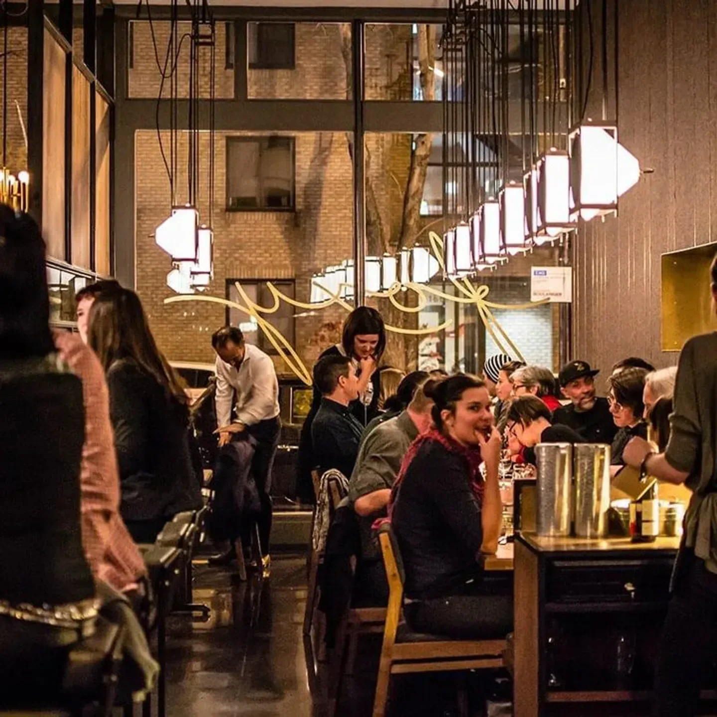 Cozy dining area at Foxy Montreal, with warm lighting and a bustling crowd.