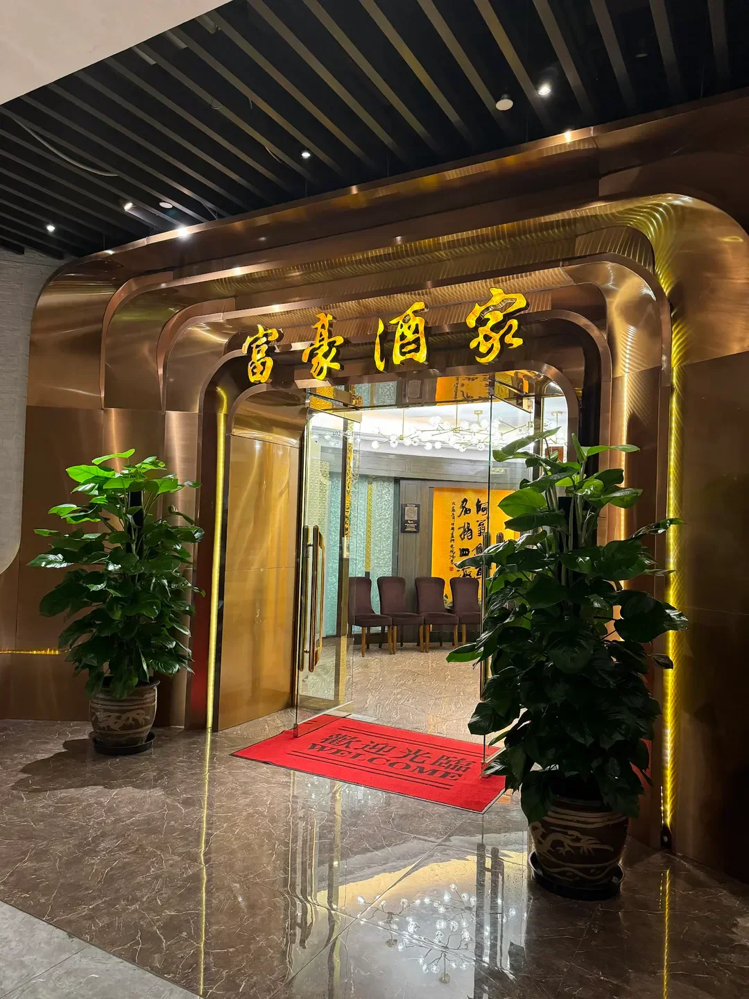 Entrance of Fu Ho (Tsim Sha Tsui) restaurant in Hong Kong with golden archway and plants.