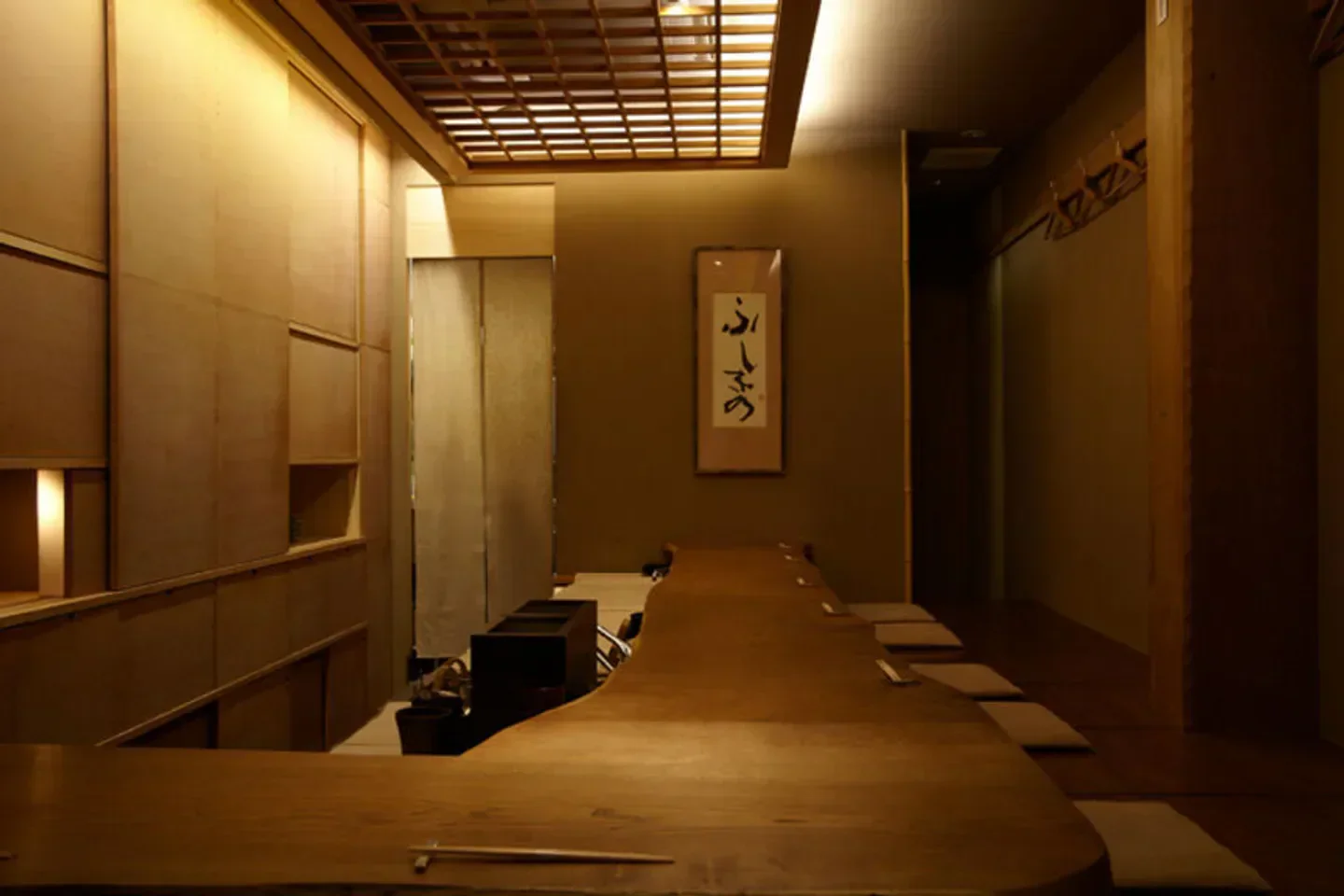 Interior of Fushikino restaurant in Tokyo, featuring elegant wooden design and a long table.