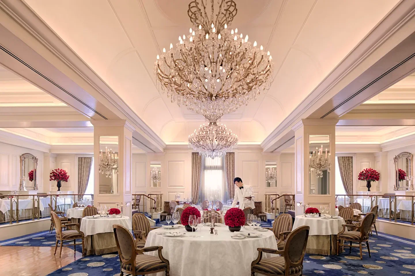 Elegant dining room at Gaddi's restaurant in Hong Kong, featuring chandeliers and tables.