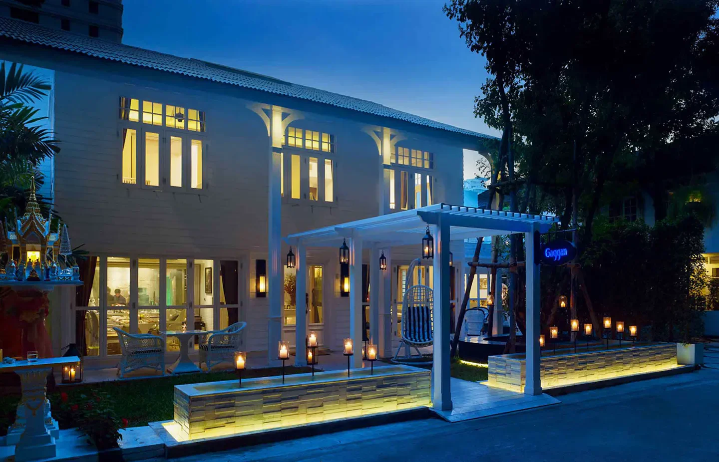 Exterior of Gaggan Anand restaurant in Bangkok at twilight, illuminated ambiance.