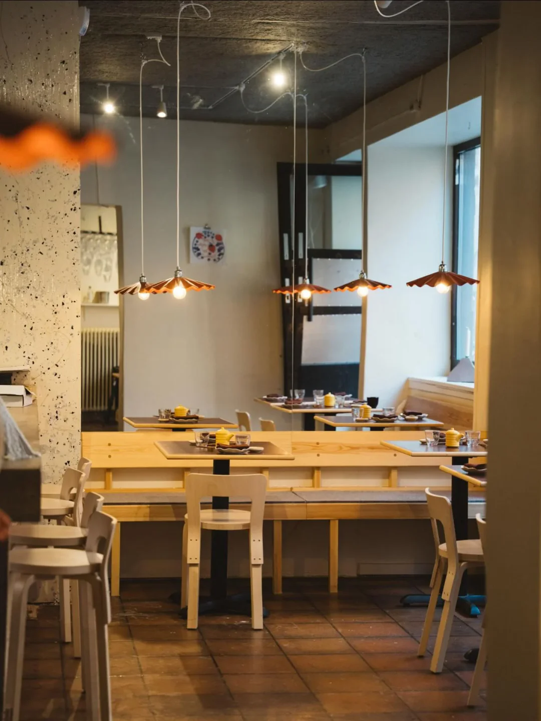 The warm and inviting interior of Gaijin restaurant in the city, featuring wooden benches and unique pendant lights.